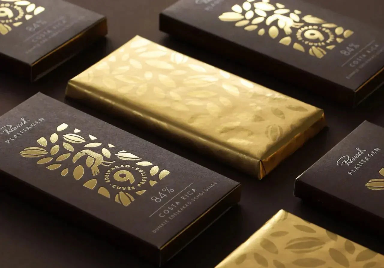 Luxuriöse Schokoladentafeln Costa Rica 84% mit goldenen Blättermotiven auf dunkler Verpackung von Rausch.
