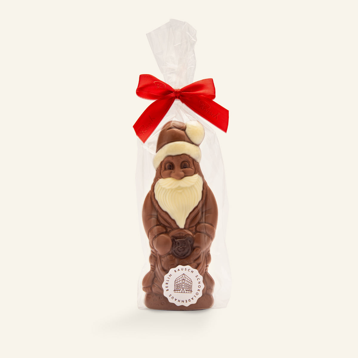 Handgefertigter Weihnachtsmann aus heller und dunkler Schokolade mit roter Schleife, verpackt in Klarsichtfolie. - Rausch