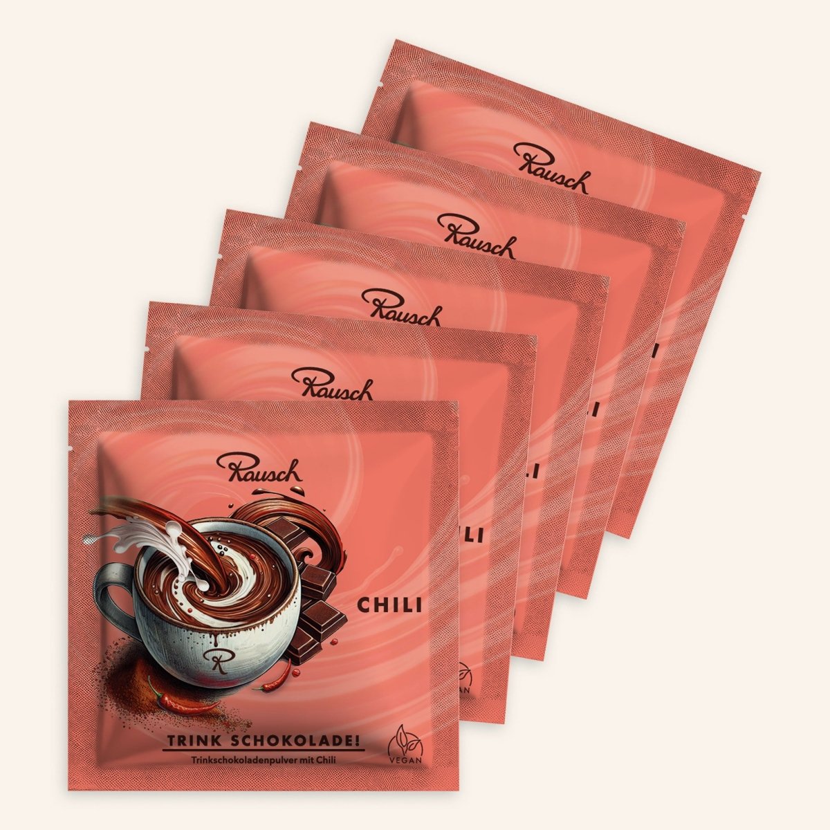 Fünf Trinkschokoladen der Sorte "Chili" in roten Sachets auf beigem Hintergrund.