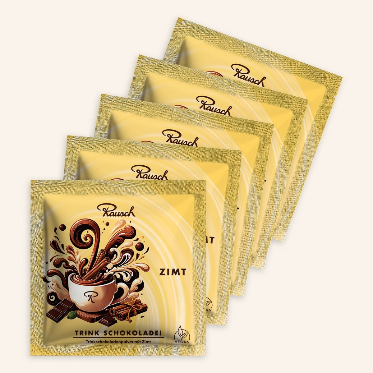 Fünf Trinkschokoladen der Sorte "Zimt" in gelben Sachets auf beigem Hintergrund.