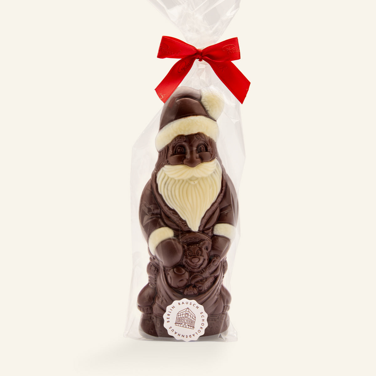 Handwerklich gefertigte dunkle Schokoladenfigur Weihnachtsmann mit roten Akzenten, verpackt mit roter Schleife. - Rausch