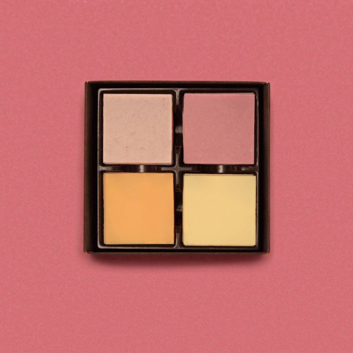 Geöffnete Schachtel Hauchfeine Täfelchen mit vier verschiedenfarbigen, fruchtigen Sorten.