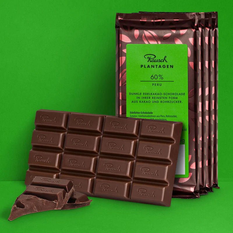 Bundle aus Rausch Plantagen Peru 60% Schokolade auf grünem Hintergrund.