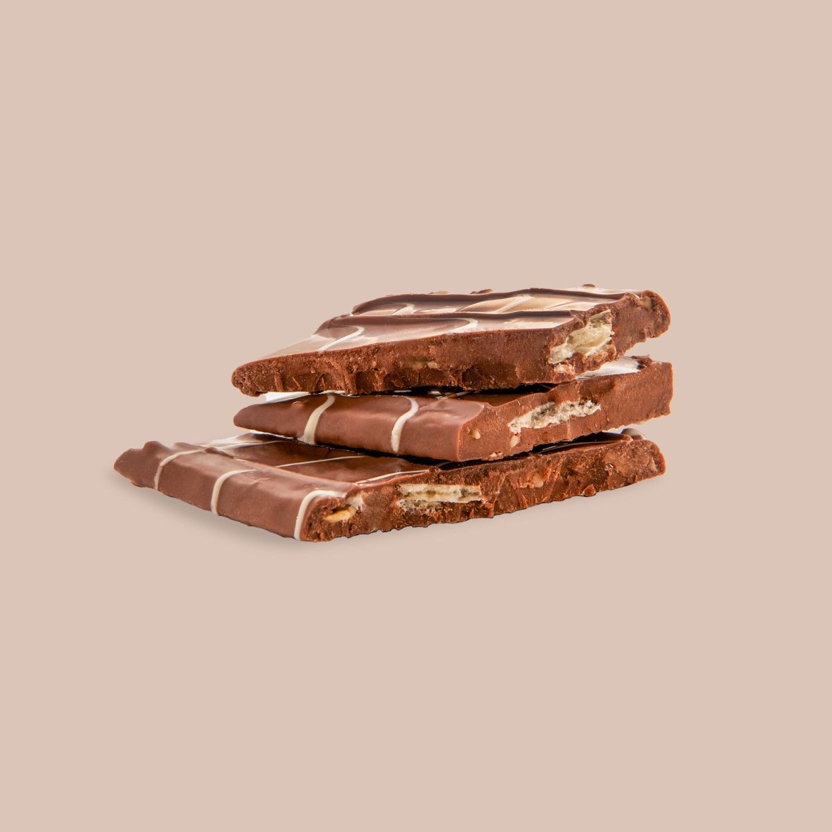 Karamellcrunch-Milchschokoladentafel im Anschnitt mit feinem weißen Muster auf beigem Hintergrund.